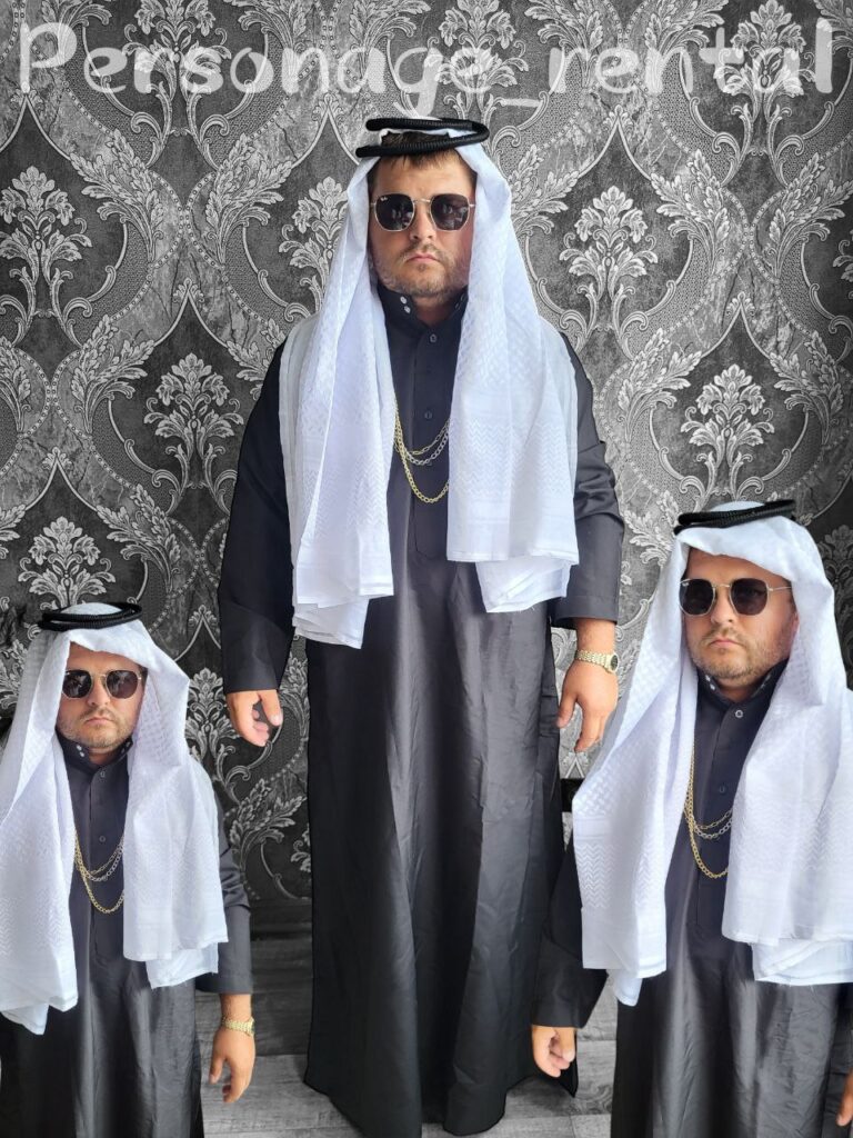 Чоловічий карнавальний костюм Арабського шейха в чорному та білому кольорах, доповнений золотими ланцюгами та сонцезахисними окулярами.